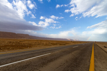 Dead sea asphalt road with white clouds and blue sky.