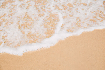 Sea wave coming on sandy beach view from top