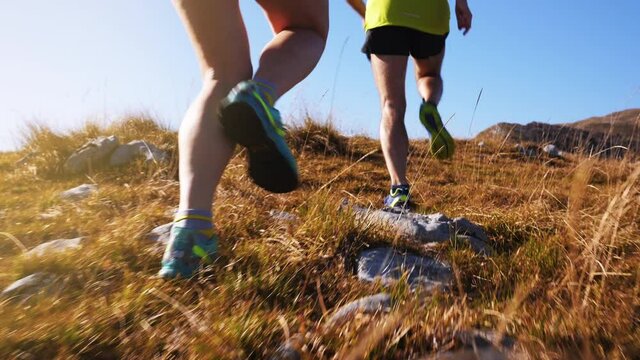 Tracking shot of marathons' legs jogging through the wasteland in slow motion