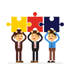 Businessmen standing holding puzzle pieces above head