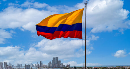 Flag wavering in front of scenic view of Cartagena modern skyline near historic city center and resort hotel zone.