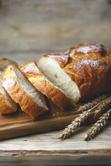 Fresh wheat bread sliced on a wooden board.