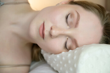 Fototapeta na wymiar Portrait of a calm young woman on pillow.