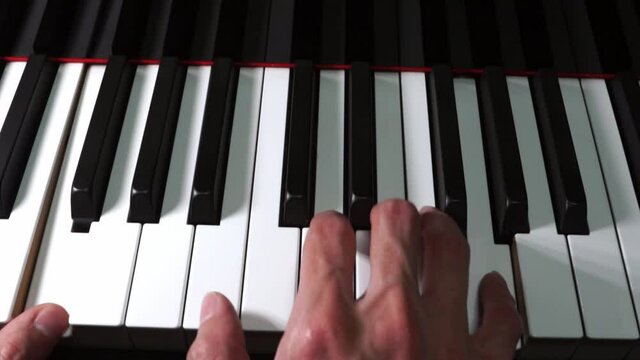 Pianist playing piano close-up on piano keys and hand on black grand piano - classical music, concert, practice, music production and recording concept