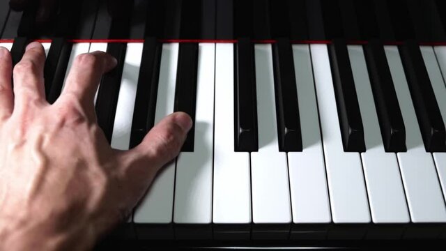 Pianist playing piano close-up on piano keys and hand on black grand piano - classical music, concert, practice, music production and recording concept