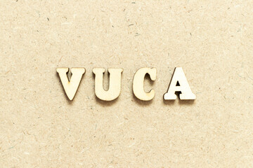 Alphabet letter in word VUCA (abbreviation of Volatility, uncertainty, complexity and ambiguity) on wood background
