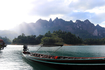 Fototapeta na wymiar Wooden thai traditional Longtail boats anchored on Cheow Lan lake, Ratchaprapha Dam, Khao Sok National Park in Thailand in a summer day