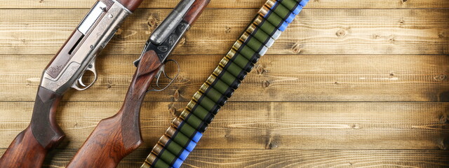 retro hunting rifles and bandolier on a wooden background, top view.