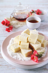 Apple gelatin dessert. Sugar free pastila. Homemade apple marshmallow cubes in coconut flakes and tea, blooming japanese quince decor