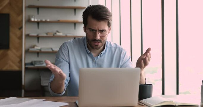 Angry stressed man office manager in glasses looks at laptop screen shocked by breakdown or operating system virus problems, unexpected error, data loss, annoyed with device stuck, need repair concept