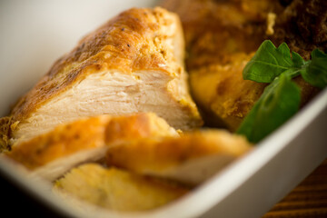 baked chicken fillet pieces with spices and herbs, in a ceramic form