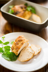baked chicken fillet pieces with spices and herbs, in a ceramic form