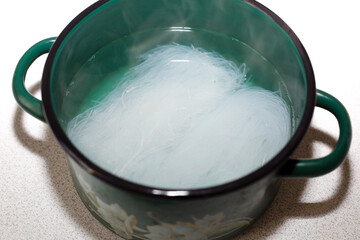 Pressed dry white vegetable noodles boiled in a saucepan