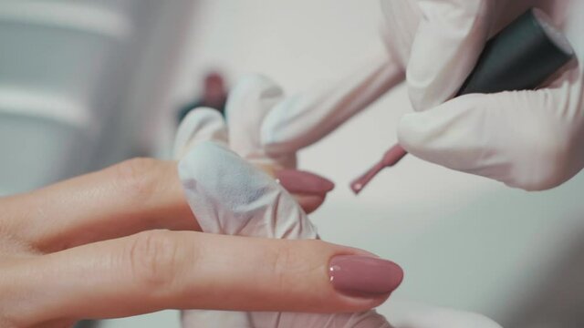 manicure artist making nail polishing with brush and tools