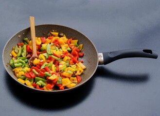 frying cut vegetables on pan close up