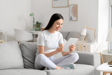 Beautiful young woman with tablet computer at home