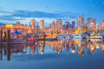 Naklejka premium Evening cityscape view from Granville Island and Vancouver, BC downtown waterfront skyline and Burrard Inlet.