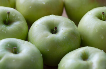 Background of green apples with water droplets, close-up