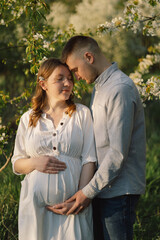 Obraz premium Young beautiful couple hugging in the spring garden.