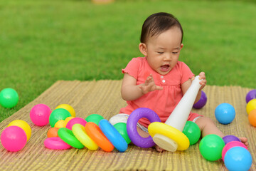 Fototapeta na wymiar Cute Asian baby girl playing with toys in playground