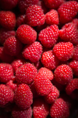 Fresh sweet juicy raspberries in a wooden basket close-up. View from above.
