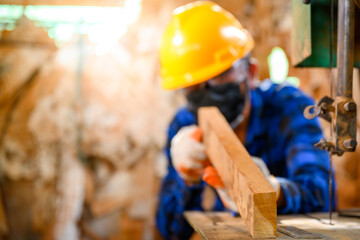 Asian male craftsmen craftsmen wood carving Cutting wood with a saw in the workshop.