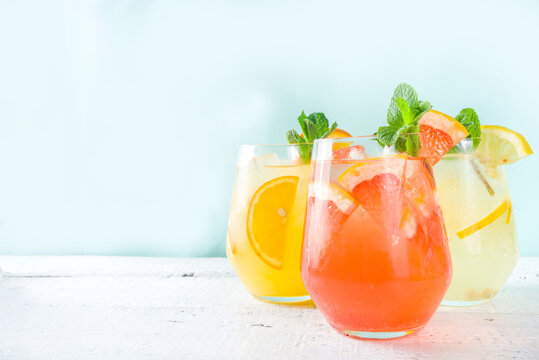 Summer cold drinks, fruit lemonade sangria cocktail, infused beverages with various citrus - orange, lemon, grapefruit, lime, with fresh fruits copy space