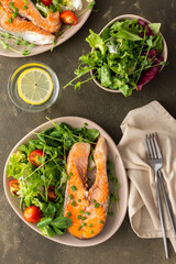 A delicious hearty lunch, a fried piece of trout steak and a mix of different types of greens salad, dinner with healthy red fish