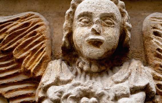 Close up fragment of an ancient stone statue of an guardian angel. Retro styled image.