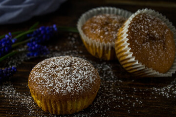 Cupcakes with orange on wooden background with blue flowers