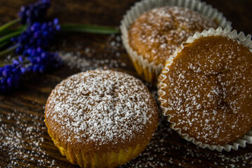 Cupcakes with orange on wooden background with blue flowers