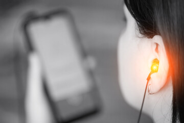 Girl listens to music loudly in headphones from a smartphone, black and white. The concept of the...