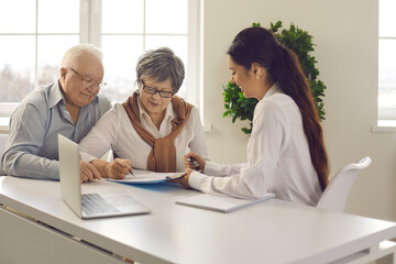 Old married family couple signing contract agreement. Aged lady putting signature on paper...