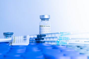 Glass bottle vial and syringe with Covid-19 Coronavirus vaccine in a research medical facility lab. Ampoules with cure on the medical worker laboratory table. Sars-cov-2 pandemic concept.