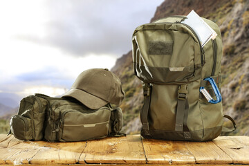 Summer backpack on desk and landscape of mountains. 