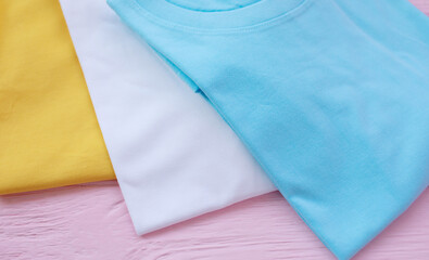 Top view of color t-shirt on wood plank background.