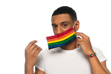 african american man with beads bracelet and safety mask in lgbt colors looking at camera isolated...