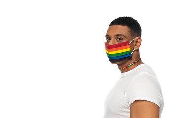 young african american man in necklace and medical mask in lgbt colors isolated on white