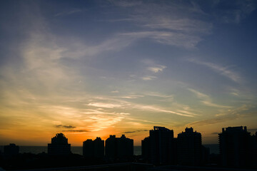 Fototapeta na wymiar sunset at sea and silhouettes of buildings