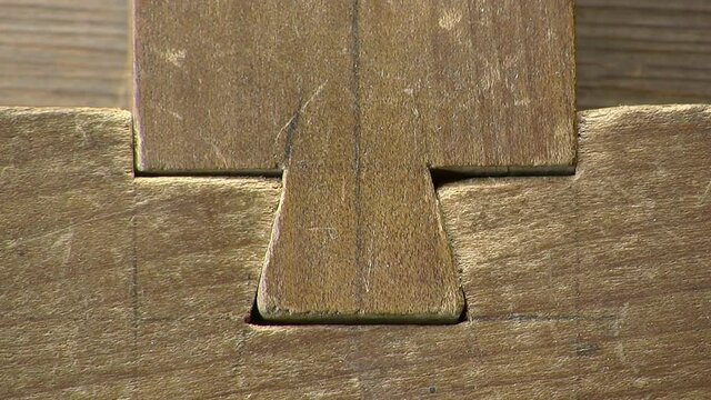 Close-up of dove-tail wood joint with pencil marks.