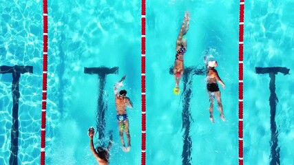 Overhead view of group of young swimmers training in swimming pool with marked lanes outdoor. Many sportive people and kids swim in Open Water Swimming pool with clean blue water. Summer sports camp