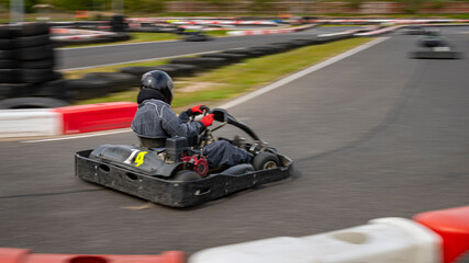 A panning shot of a racing kart as it circuits a track.