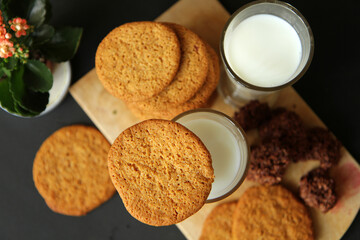 Almond cookies with nuts on a wood plank. cup of milk