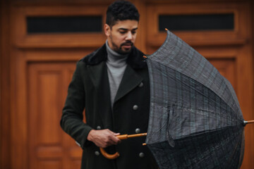 Afro male assembling the umbrella while he is in a walk