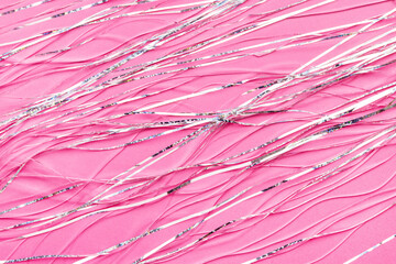 Pink shiny holographic tinsel background. Festive or party wallpaper.