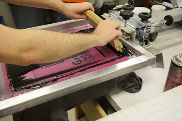 Screen printing, or silk screening, with black plastisol on t-shirts and posters.