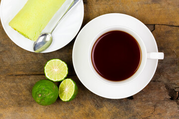 Bergamot tea or Earl Grey tea in ceramic cup and fresh bergamot fruit with sliced on brown rustic wooden table, top view.