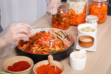 Asian woman sitting and making kimchi She is wearing protective gloves. To keep food clean. White background Korean fermented food concept made from vegetables.