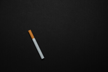 A Cigarette with Yellow filter on a black background.