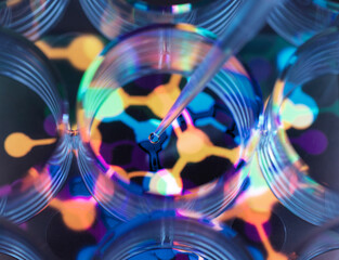 Conceptual image to illustrate biotechnology, Scientist pipetting chemical formula into multi well plate during an experiment